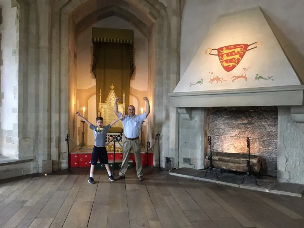 Father and son in front of a fire place in the Tower of London.