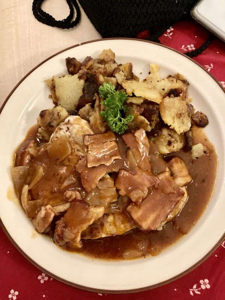 German meal of chicken and bacon with potatoes and gravy