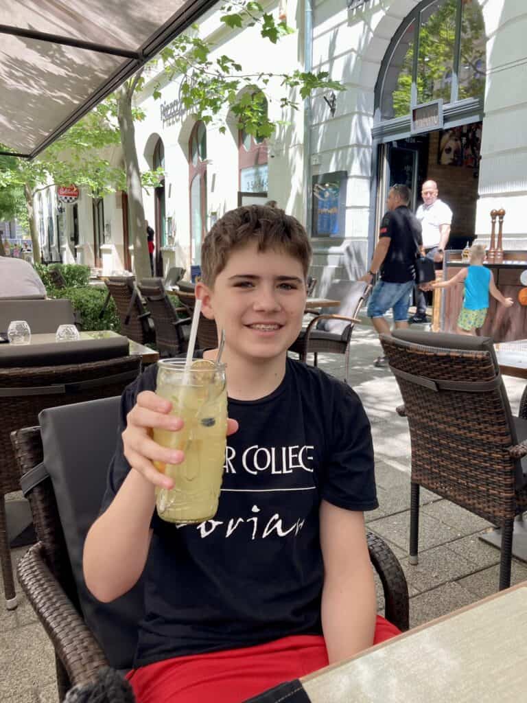 A boy holding lemonade in Budapest.