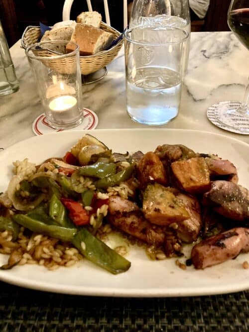 Plate showing grilled octopus, pumpkin, rice, and vegetables