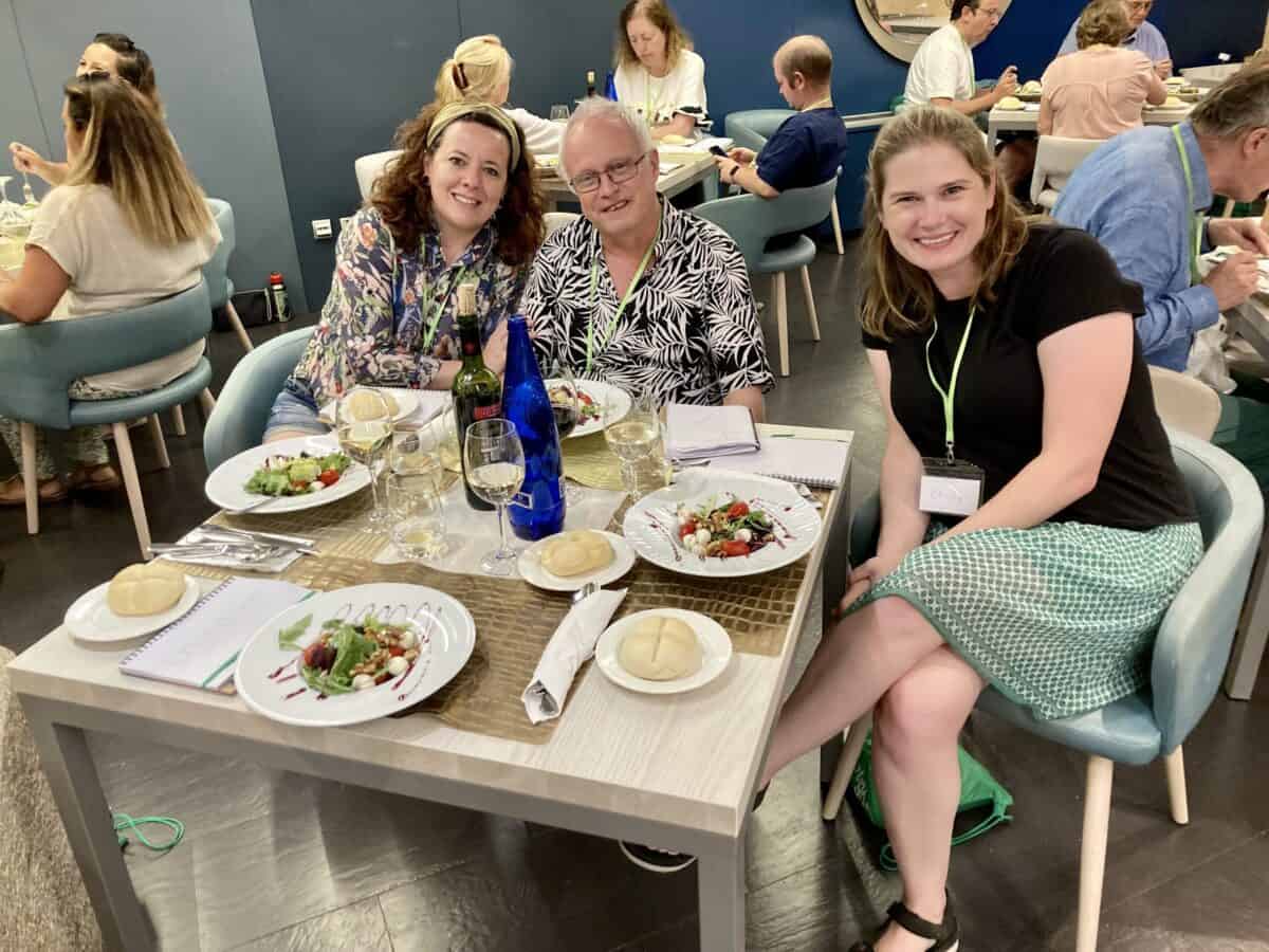 Two women and a man sitting at a dinner table