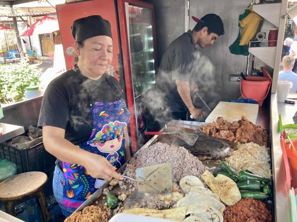 A woman prepares food at a taco restaurant in Puerto Vallarta