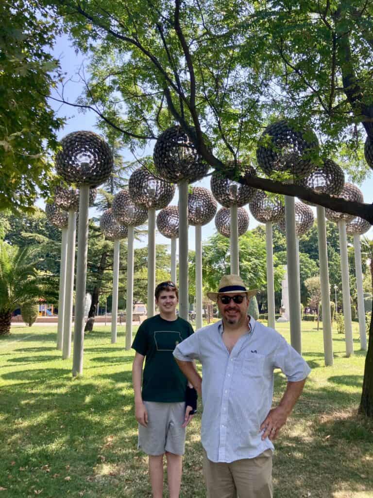 Man and boy in front of sculpture in Albania