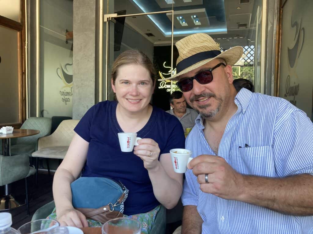 Man and woman holding small coffee cups in a coffee shop in Shkoder, Albania