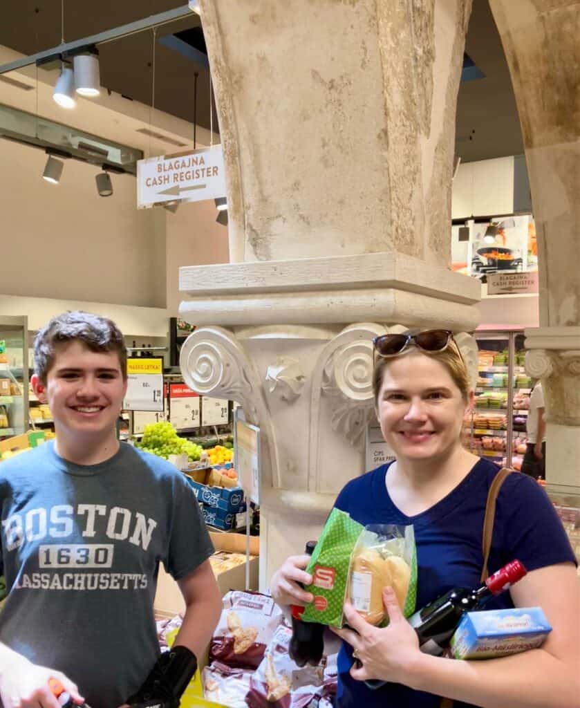 Teen boy and woman in a grocery store in Split, Croatia