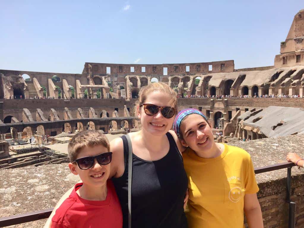 Woman with a boy and girl standing in front of Roman Colosseum