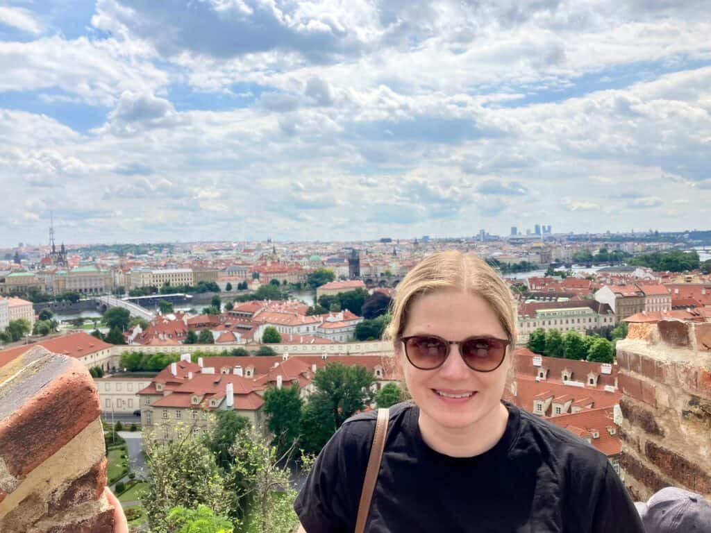 Woman standing on a hill with Prague behind her