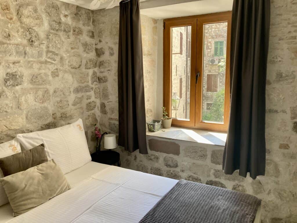 View of a bed inside a room with stone walls