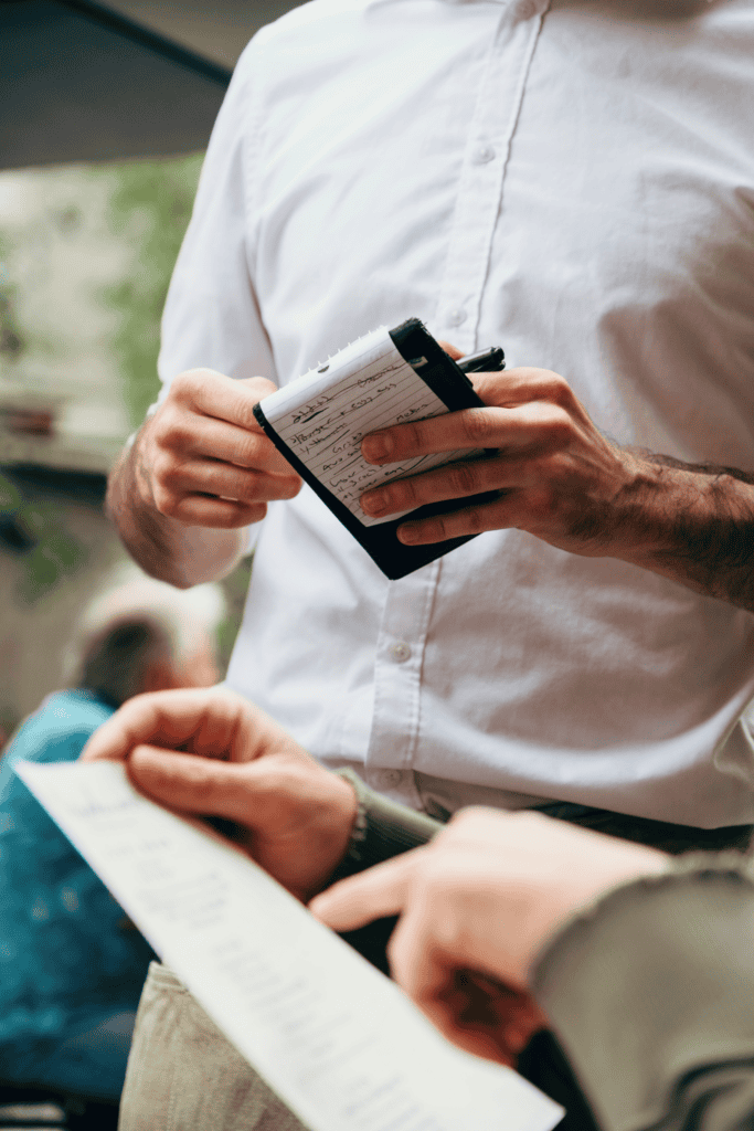 waiter's hands holding an ordering pad