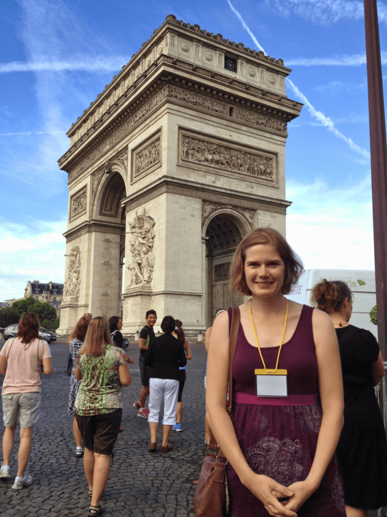 Woman standing in front of Arc de Triomphe