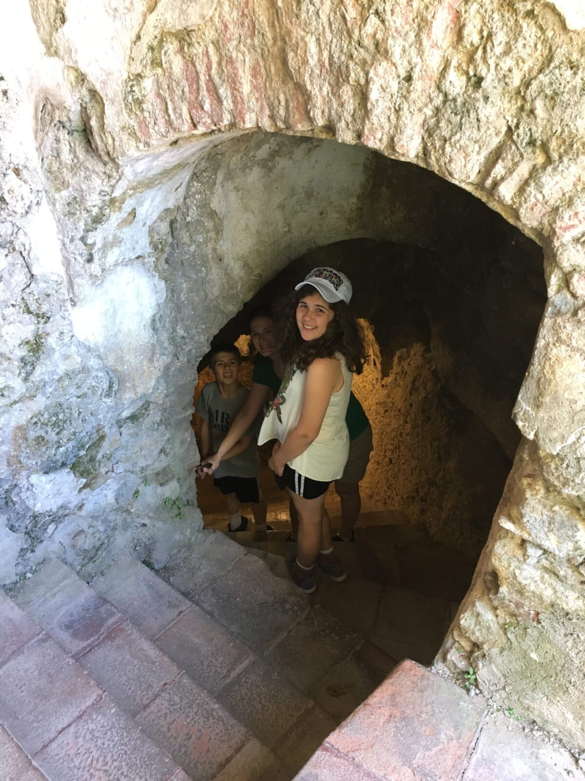 Woman and two children walking down the steps to the water mine in Ronda, Spain