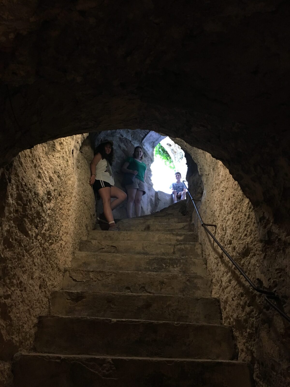 Woman and two children standing at the top of stairs in Ronda, Spain