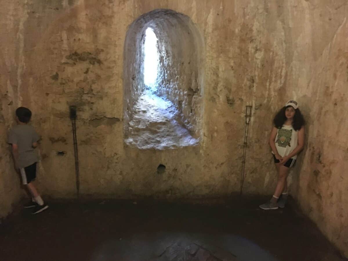 Boy and girl standing in stone room in water mine, ronda, spain