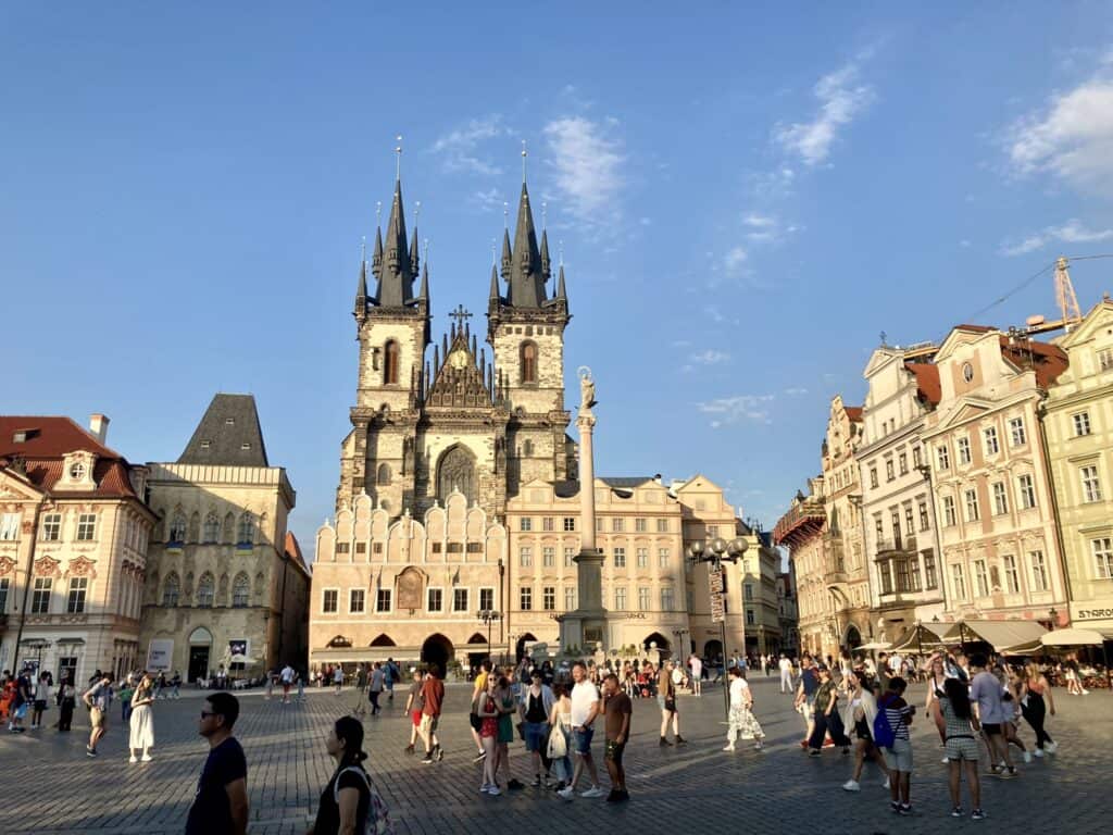 Old Town Square in Prague with people milling around at sunset.