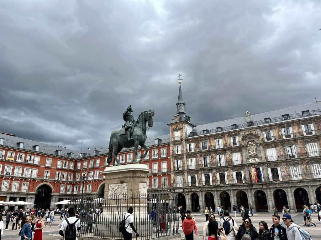 Image of a statue of a man riding a horse in the middle of Plaza Mayor, Madrid, Spain