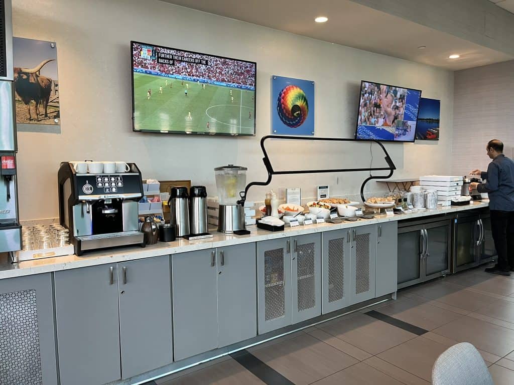 Buffet of food and coffee machines with a TV above it