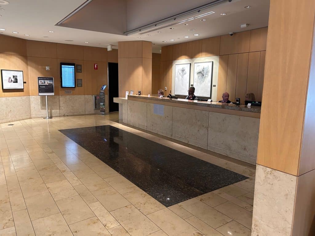 People sitting at a desk at the entrance to an Admiral's Club Lounge